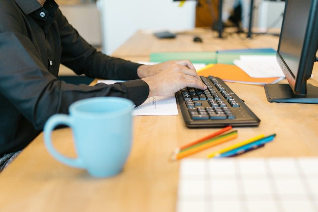 person in black long sleeve shirt typing on the keyboard