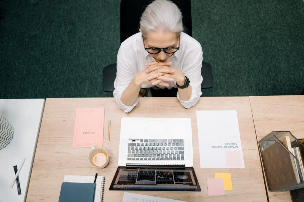 woman with gray hair sitting in front of a laptop