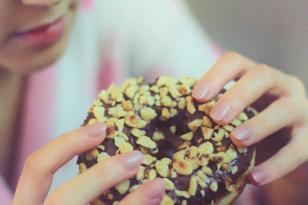 person holding chocolate doughnut