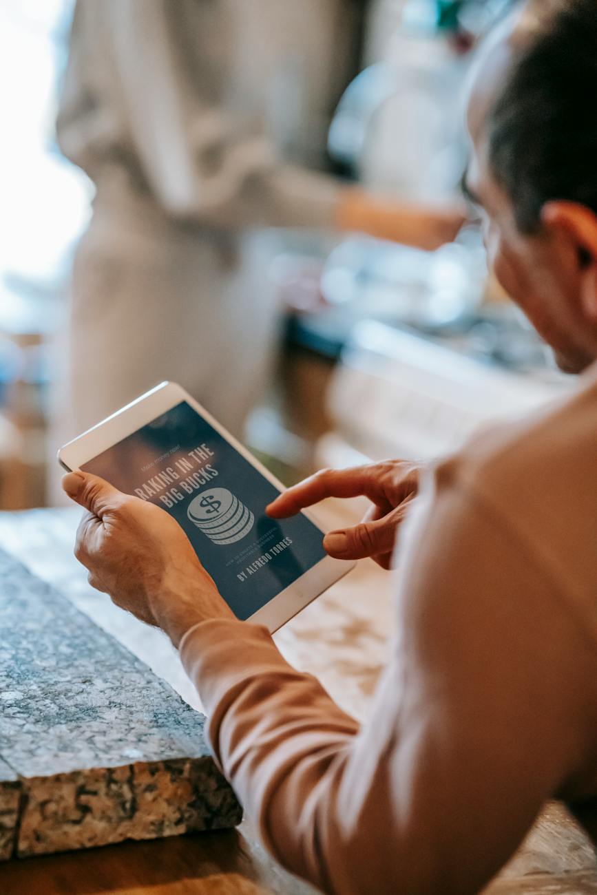 anonymous man working remotely on tablet during breakfast with wife in kitchen
