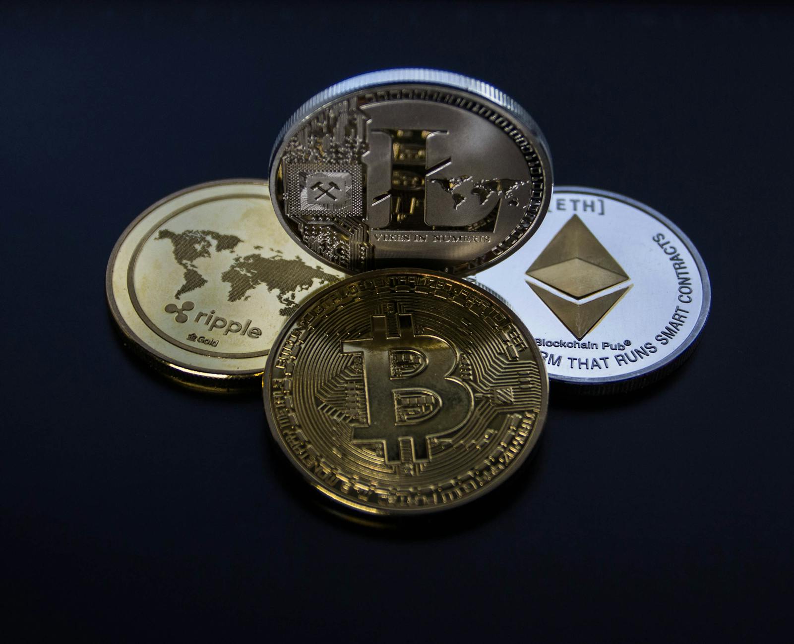 four assorted cryptocurrency coins