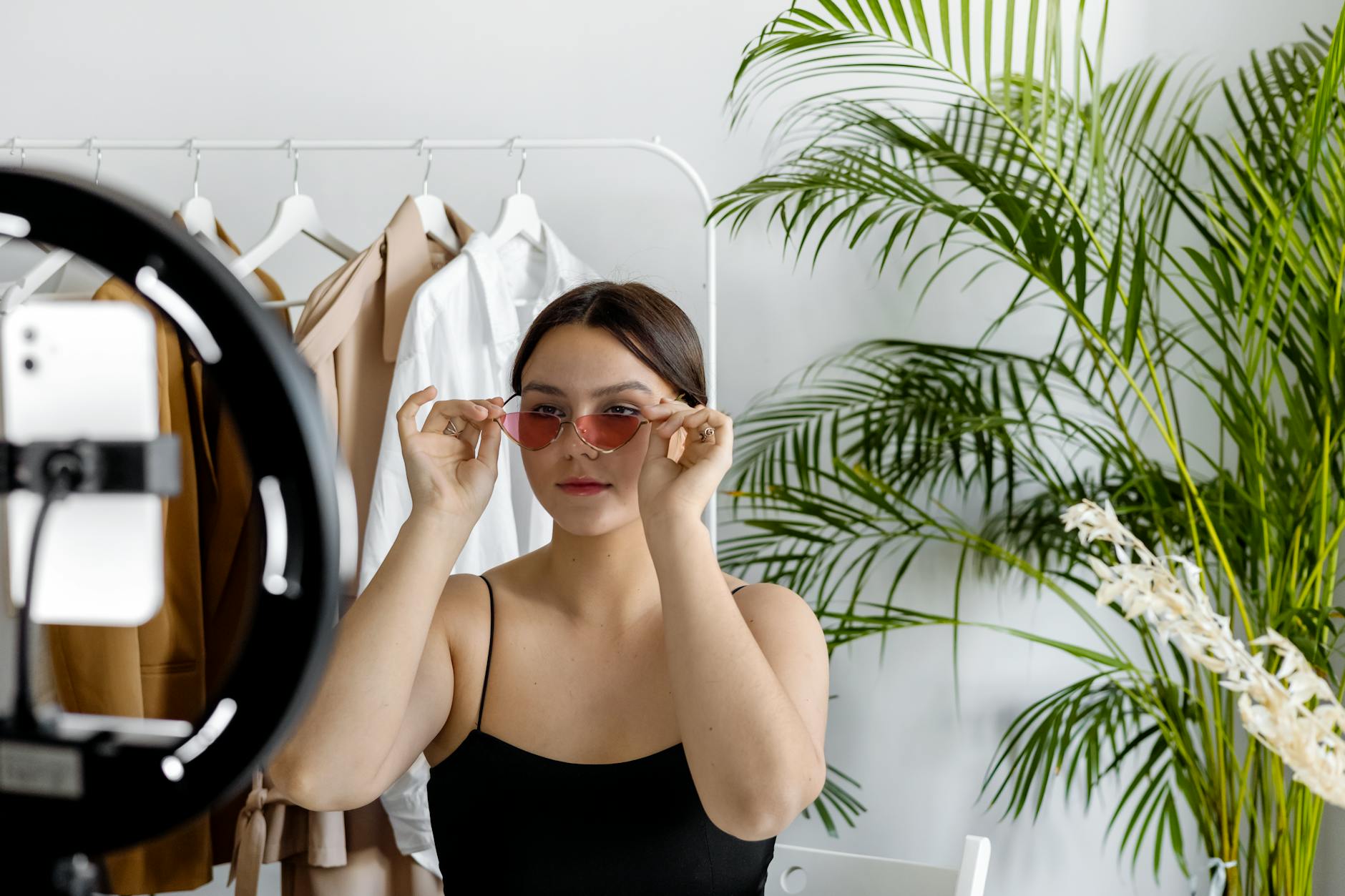 a woman showing her sunglasses to a video recording
