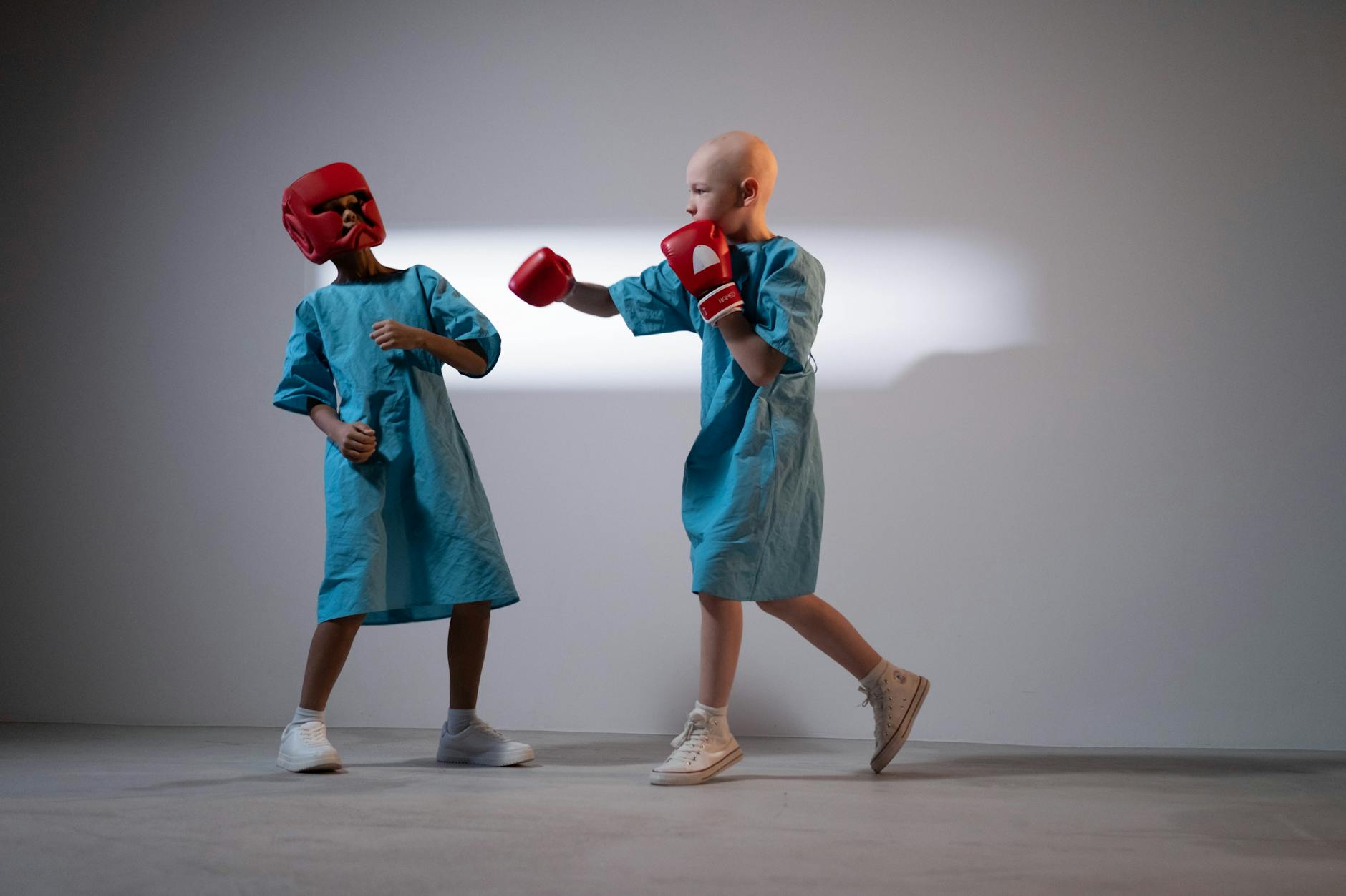 child wearing a hospital gown and boxing gloves